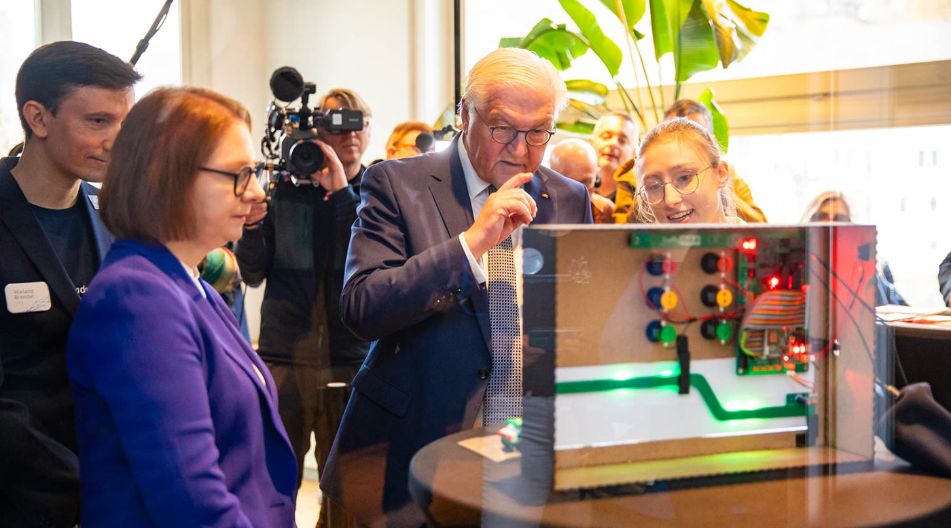 Bundespräsident Frank-Walter Steinmeier und Staatssekretärin Sandra Boser vom baden-württembergischen Kultusministerium lassen sich beim Finale 2024 die besten KI-Projekte erklären.