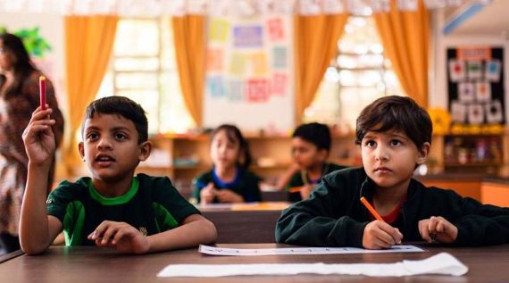 Zwei Kinder sitzen an Schreibtischen in einem Klassenzimmer und konzentrieren sich auf ihre Aufgaben.