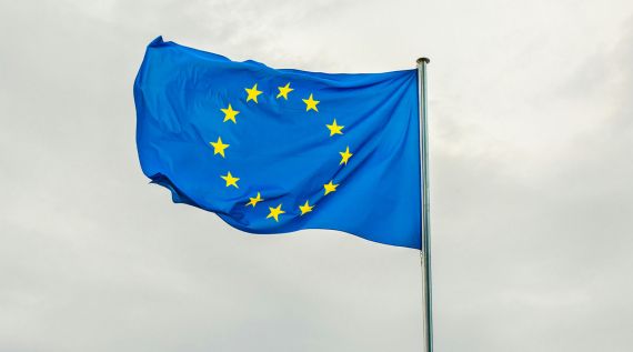 Die Flagge der Europäischen Union weht hoch am Himmel.