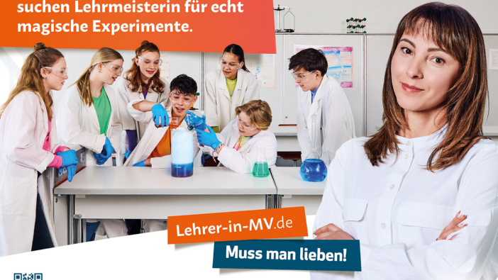 Werbeplakat für Lehrer-in-MV.de: Eine Gruppe von Schülern in Laborkitteln experimentiert begeistert mit chemischen Substanzen, während eine junge Lehrerin im Vordergrund selbstbewusst in die Kamera blickt. Text: „Angehende Zauberlehrlinge suchen Lehrmeisterin für echt magische Experimente.“ und „Lehrer-in-MV.de – Muss man lieben!“. QR-Code und Logo von „MV tut gut.“ unten rechts.