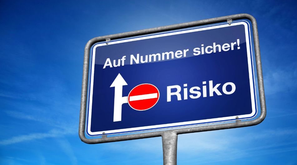 Ein blaues Verkehrsschild mit der Aufschrift „Auf Nummer sicher!“ und „Risiko“, wobei der Weg zum Risiko durch ein Verbotsschild blockiert ist.