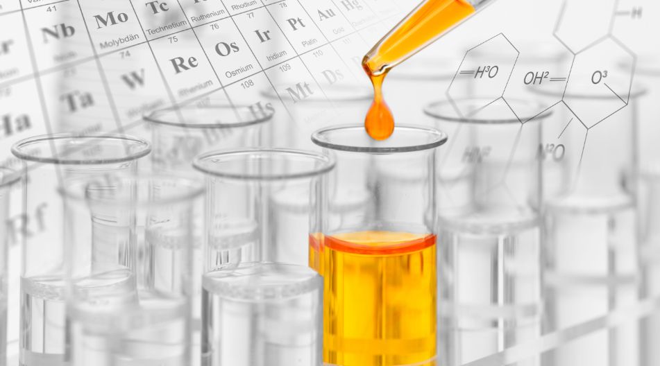 Chemisches Reagenzglas, in das orangefarbige Flüssigkeit gegossen wird, symbolisiert Experimente in der Chemie.